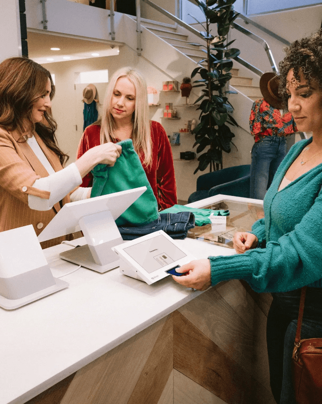 Customer paying at a Clover POS terminal in a boutique